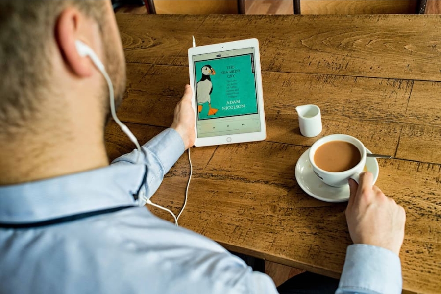 eLibrary man listening to audio book with a coffee