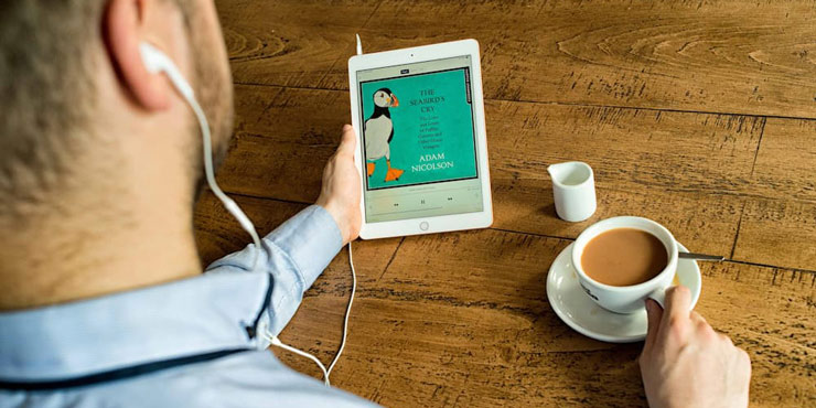 Man listening to an audiobook whilst enjoying a cup of tea