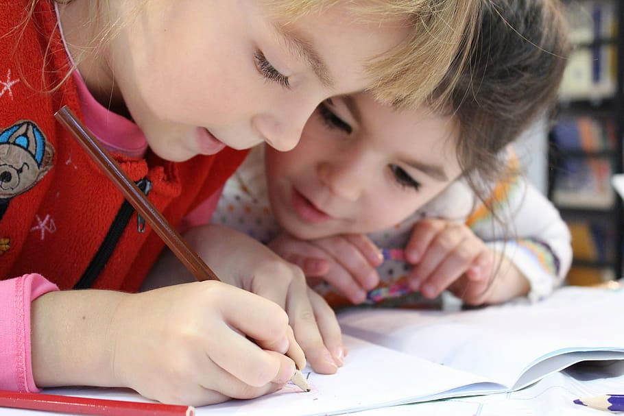 Activity sheets Two children doing activity sheets together