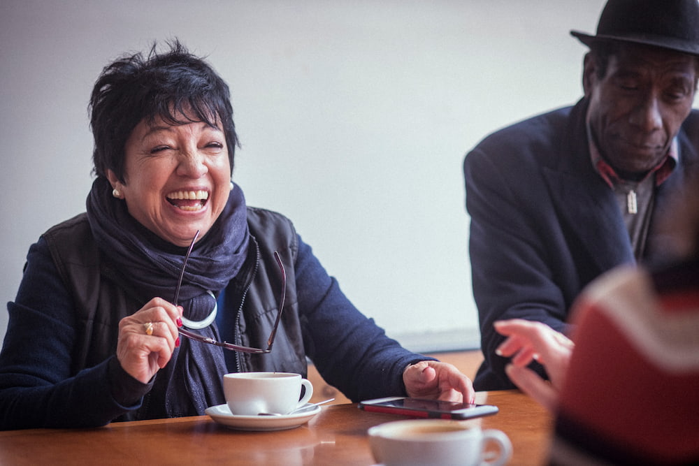 Group of older people having coffee and smiling
