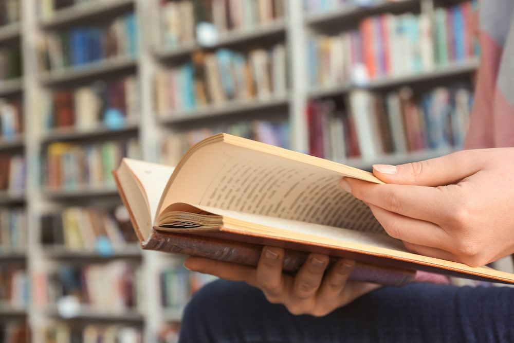 Close up of someone reading a book in a library