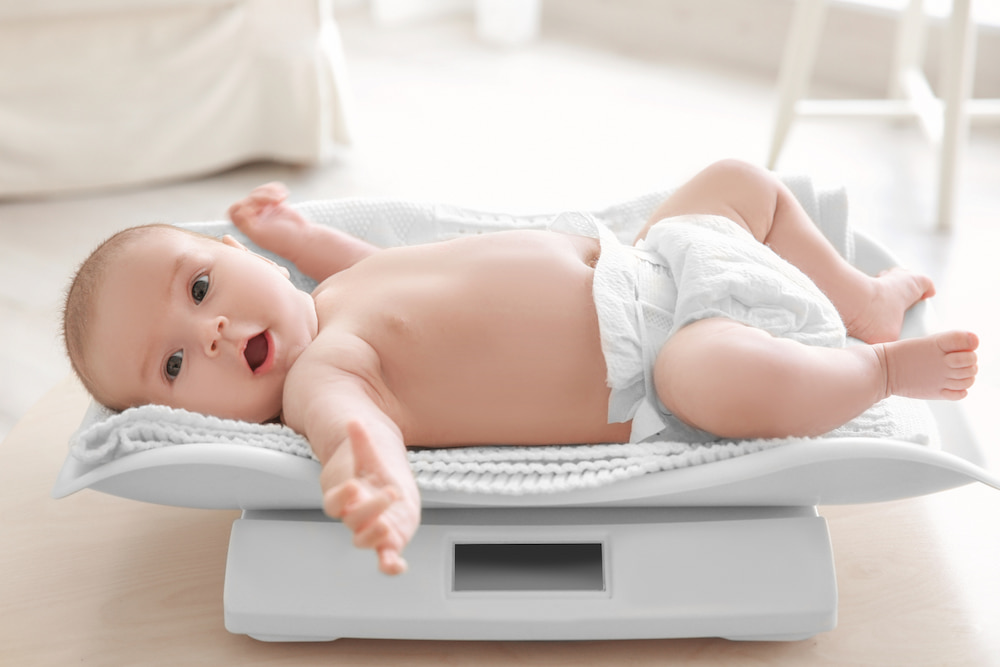 Baby lying on scales being weighed