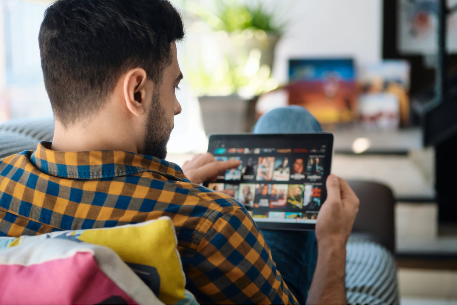 A man browsing streaming films on a tablet