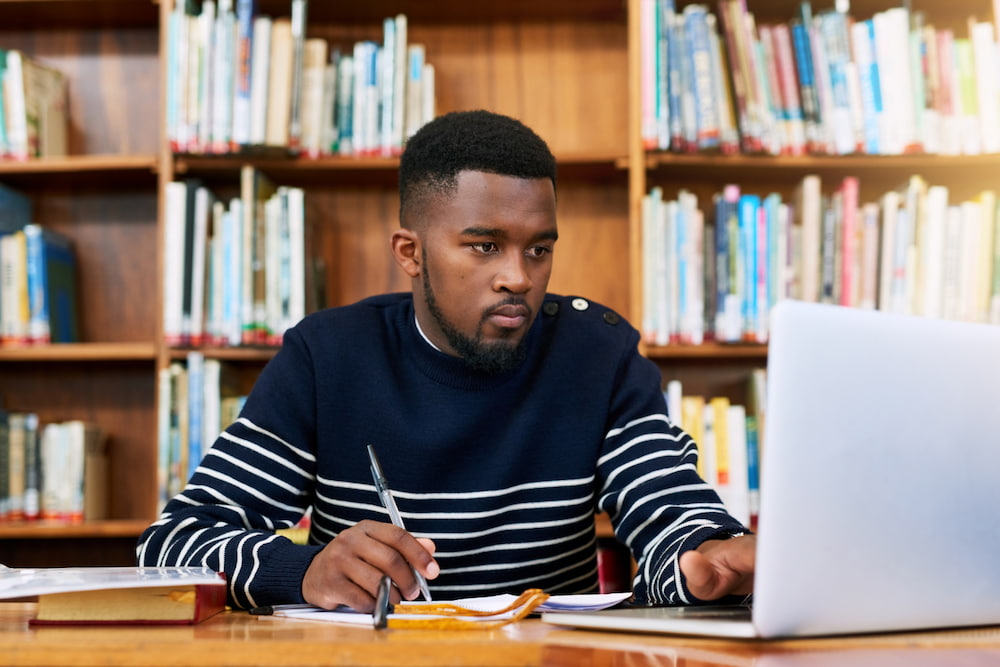 University student on laptop in a library