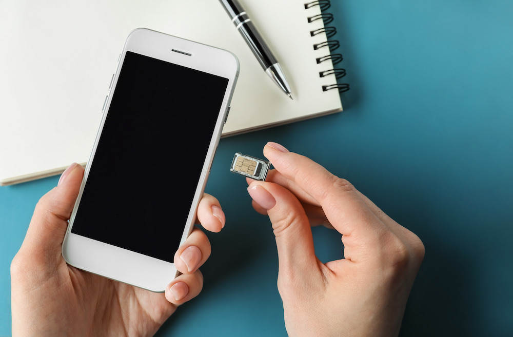 A person putting a SIM card into a phone