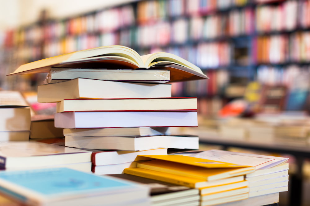 Stack of books in front of shelves