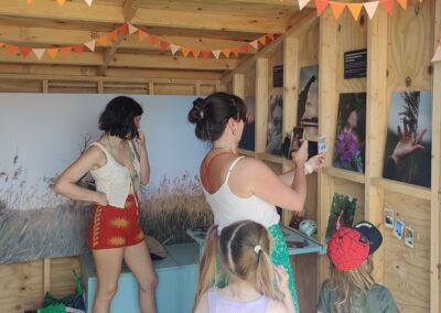Festival-goers enjoying Charlotte's display inside the beach hut at First Light Festival.